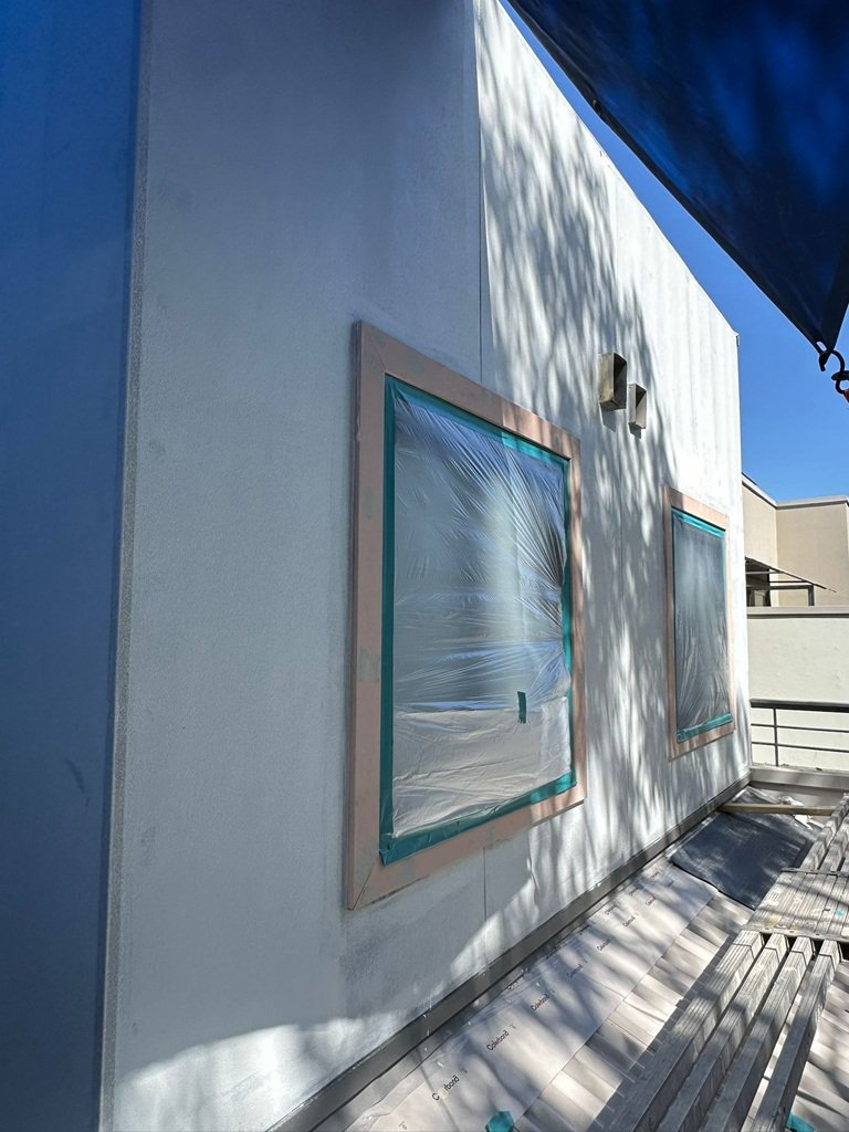 Windows masked and protected before spraying a rendered strata building in Sydney